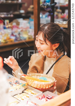 一位年輕女子懷舊地在老式糖果店購物[照片合作：大米/粗點心店加賀田Beikokuten] 121543749
