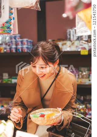 一位年輕女子懷舊地在老式糖果店購物[照片合作：大米/粗點心店加賀田Beikokuten] 121543750