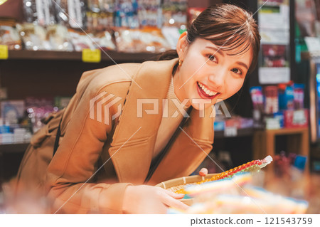 一位年輕女子懷舊地在老式糖果店購物[照片合作：大米/粗點心店加賀田Beikokuten] 121543759