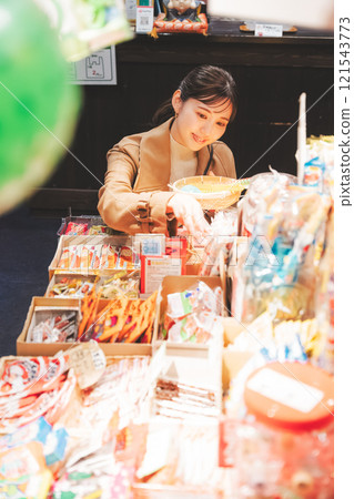 一位年輕女子懷舊地在老式糖果店購物[照片合作：大米/粗點心店加賀田Beikokuten] 121543773