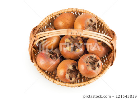 Brown fresh medlars in a wicker basket isolated on white background. Mespilus germanica . Top view. Flat lay Brown fresh medlars in a wicker basket isolated on white background. Mespilus germanica . Top view. Flat lay 121543819