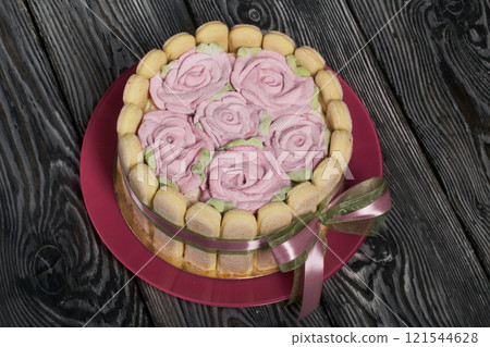 Cake with Savoiardi cookies and marshmallow roses. Tied with ribbon. The ribbon is tied into a bow. 121544628