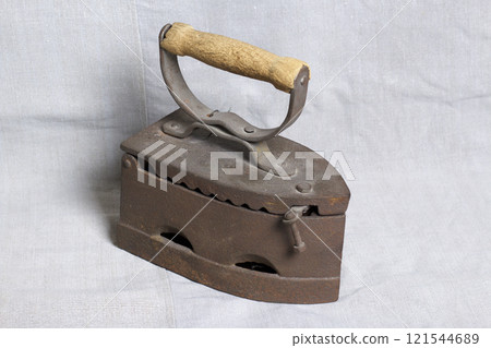 Old iron, heated by hot coals. Located on linen fabric. 121544689