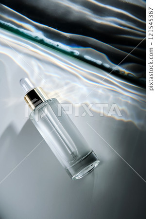Bottle of face serum with a pipette with a beautiful highlight. 121545367