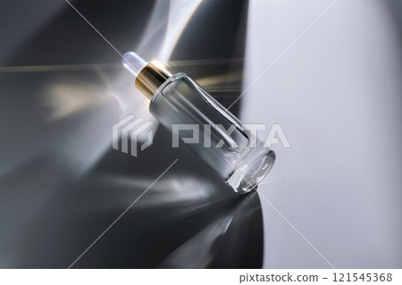 Bottle of face serum with a pipette with a beautiful highlight. 121545368