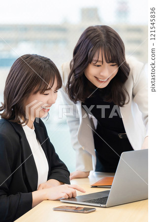 使用計算機的兩名女商人 使用計算機的兩名女商人 121545836