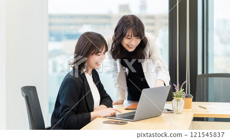 Two women/businesswomen using a computer 121545837