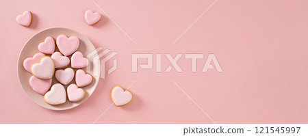 Valentine's Day heart shaped pink glazed cookies in plate on pink background. View from above. Copy space. Banner. Love concept. Valentine's Day heart shaped pink glazed cookies in plate on pink background. View from above. Copy space. Banner. Love concept. 121545997
