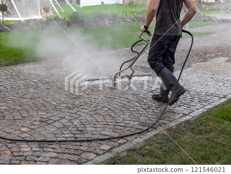 Professional cleaning service worker power washing cobblestone Professional cleaning service worker power washing cobblestone 121546021