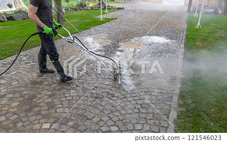 Professional cleaning service worker washing cobblestone 121546023