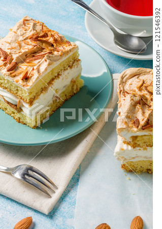 Norwegian cake. With meringue, whipped cream and almonds. Light background. Norwegian cake. With meringue, whipped cream and almonds. Light background. 121546392