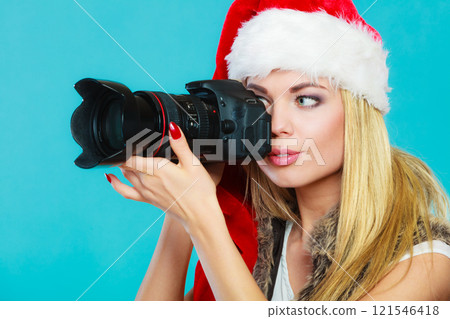Photographer girl in santa claus hat shooting images Photographer girl in santa claus hat shooting images 121546418