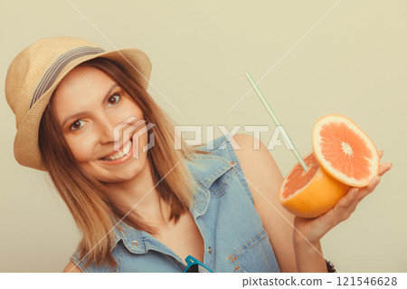 Glad woman in hat holding grapefruit Glad woman in hat holding grapefruit 121546628