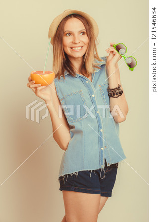 Happy woman in hat drinking grapefruit juice. Diet 121546634