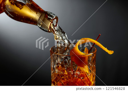 Whiskey or bourbon pouring into a crystal glass. Whiskey or bourbon pouring into a crystal glass. 121546828