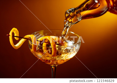 Old-fashioned cocktail garnished with orange peel. 121546829