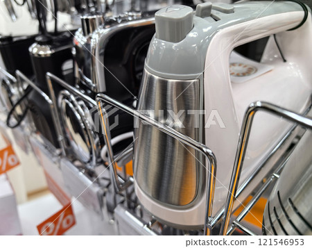 Mixers displayed on a tidy counter in a bustling appliance store 121546953