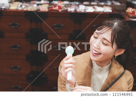 一位年輕女子懷舊地在老式糖果店購物[照片合作：大米/粗點心店加賀田Beikokuten] 121546991