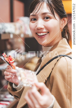 一位年輕女子懷舊地在老式糖果店購物[照片合作：大米/粗點心店加賀田Beikokuten] 121547012