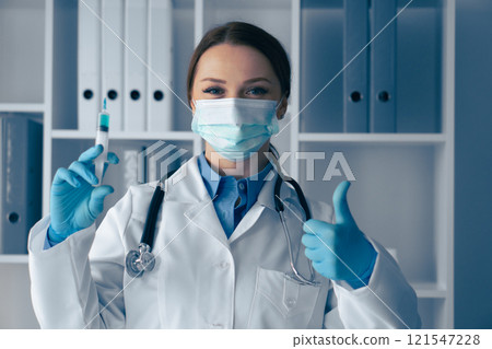 A confident healthcare professional in gloves and a mask holds a vaccine syringe with focus, demonstrating dedication to patient care and public health, while embodying trust in a clinical setting A confident healthcare professional in gloves and a mask holds a vaccine syringe with focus, demonstrating dedication to patient care and public health, while embodying trust in a clinical setting 121547228