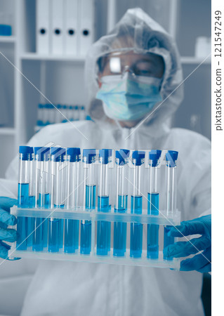 A Laboratory Technician skillfully analyzing a variety of test tubes filled with vibrant blue solutions, contributing to critical research in the fields of biotechnology and healthcare A Laboratory Technician skillfully analyzing a variety of test tubes filled with vibrant blue solutions, contributing to critical research in the fields of biotechnology and healthcare 121547249