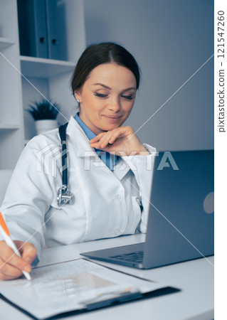 Thoughtful Medical Professional Engaged at Work, Demonstrating Dedication to Patient Care, Utilizing Technology for Analysis and Treatment Decisions in a Professional Healthcare Environment Thoughtful Medical Professional Engaged at Work, Demonstrating Dedication to Patient Care, Utilizing Technology for Analysis and Treatment Decisions in a Professional Healthcare Environment 121547260