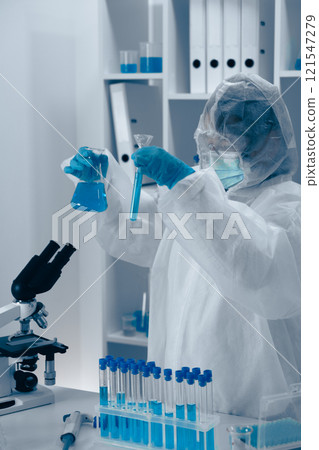 A dedicated scientist conducts detailed experiments in a fully equipped lab with specialized glassware and advanced equipment, demonstrating a strong commitment to innovation in biochemistry 121547279