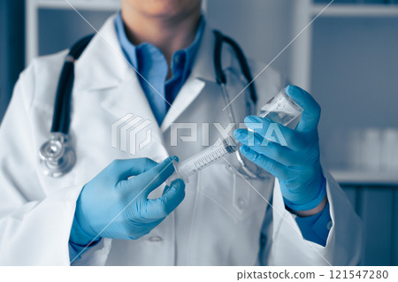 A dedicated medical professional meticulously prepares the syringe with careful precision, ensuring all safety and sanitation protocols are strictly followed for optimal patient care and treatment A dedicated medical professional meticulously prepares the syringe with careful precision, ensuring all safety and sanitation protocols are strictly followed for optimal patient care and treatment 121547280