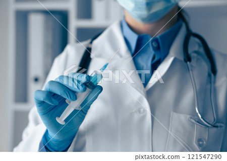 A healthcare professional diligently preparing a vaccine for administration in a clinic setting, showcasing the importance of careful procedures and adhering to safety protocols ahead of treatment 121547290