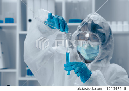 A scientist is carefully conducting an intricate experiment involving a test tube within a wellequipped laboratory setting to explore various facets of biochemistry and healthcare innovations 121547346