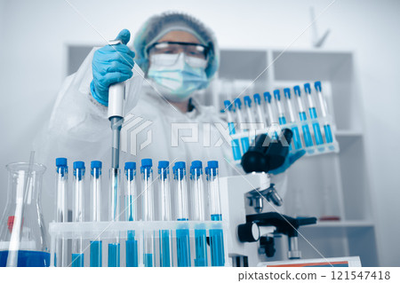 A scientist is currently engaged in research and working diligently within a stateoftheart laboratory, utilizing various test tubes and equipment to conduct precise scientific experiments 121547418