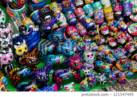 Street sale of handicrafts alluding to the Day of the Dead in Mexico City. Cups decorated with colorful skulls. Alebrijes. 121547495