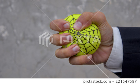 Close-Up of a Hand Squeezing a Stress Ball with Web Design 121547587