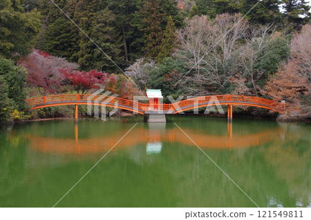 紅色的橋反射在池塘的表面 紅色的橋反射在池塘的表面 121549811