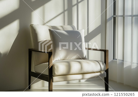 Simple chair with a blank throw pillow in a bright, sunlit room with ample copy space 121550265