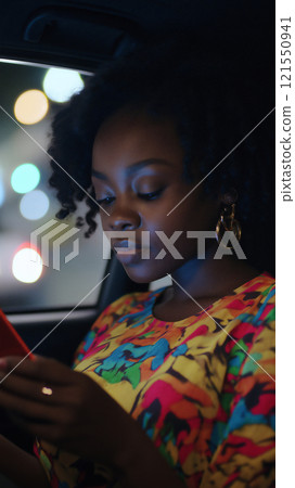 Young woman engaging with a vibrant tablet in a dimly lit setting. Generative AI 121550941