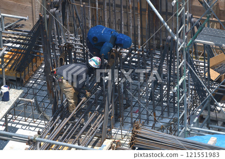 Reinforcement workers at work at a new apartment building construction site 121551983