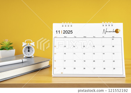 November desk calendar for 2025 year on work table with yellow. 121552192