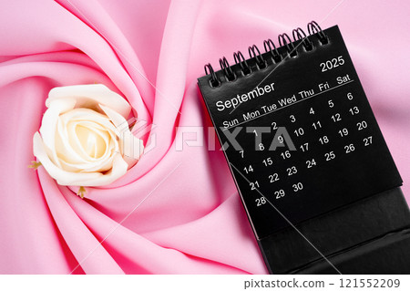 September 2025 desk calendar black color and rose on pink textile. September 2025 desk calendar black color and rose on pink textile. 121552209