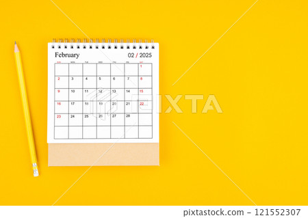 February 2025 desk calendar and wooden pencil on yellow color background. February 2025 desk calendar and wooden pencil on yellow color background. 121552307
