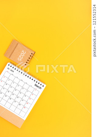 2025 March Desk Calendar On Yellow Background, Position with copy space On Yellow Background. 121552314