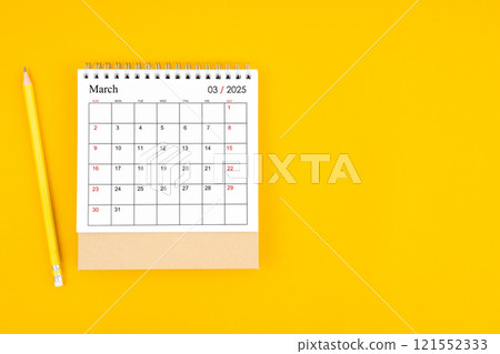 March 2025 desk calendar and wooden pencil on yellow color background. 121552333
