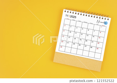 November 2025 desk calendar on yellow color background. 121552522