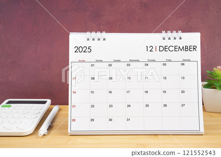 December 2025 white calendar and calculator with pen. 121552543