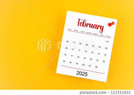 February 2025 calendar page with red push pin on yellow background. February 2025 calendar page with red push pin on yellow background. 121552831