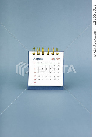 August 2025 white desk calendar on blue background. 121553015