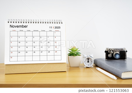 Desktop Calendar for November 2025 year and vintage camera with diary for Planner to plan timetable. 121553063