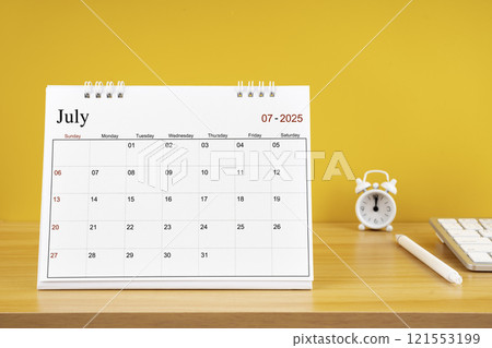July 2025, Monthly desk calendar for 2025 year on wooden table. 121553199