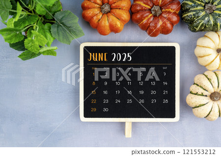 View from above to simple June 2025 calendar decorated with pumpkins. 121553212