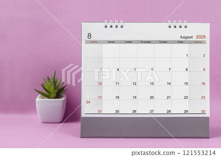 August 2025 desk calendar for 2025 on pink background. 121553214